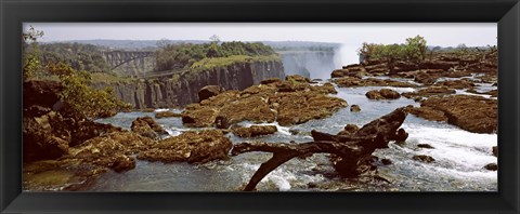 Framed Log on the rocks at the top of the Victoria Falls with Victoria Falls Bridge in the background, Zimbabwe Print