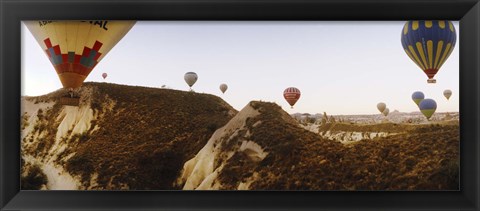 Framed Hot air balloons soaring over a mountain ridge, Cappadocia, Central Anatolia Region, Turkey Print