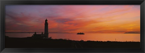 Framed Silhouette of a lighthouse at sunset, Scotland Print