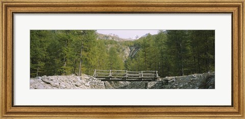 Framed Wooden footbridge across a stream in a mountain range, Switzerland Print
