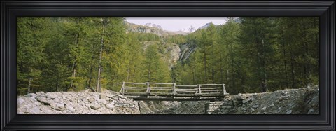 Framed Wooden footbridge across a stream in a mountain range, Switzerland Print