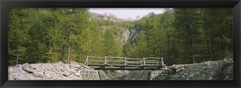 Framed Wooden footbridge across a stream in a mountain range, Switzerland Print