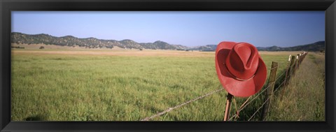 Framed USA, California, Red cowboy hat hanging on the fence Print