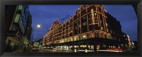 Framed Low angle view of buildings lit up at night, Harrods, London, England Print