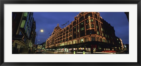Framed Low angle view of buildings lit up at night, Harrods, London, England Print