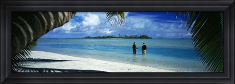 Framed Rear view of two native teenage girls in lagoon, framed by palm tree, Aitutaki, Cook Islands. Print