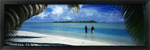 Framed Rear view of two native teenage girls in lagoon, framed by palm tree, Aitutaki, Cook Islands. Print