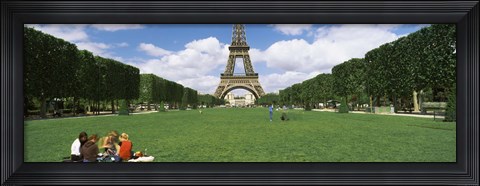 Framed Tourists sitting in a park with a tower in the background, Eiffel Tower, Paris, Ile-de-France, France Print