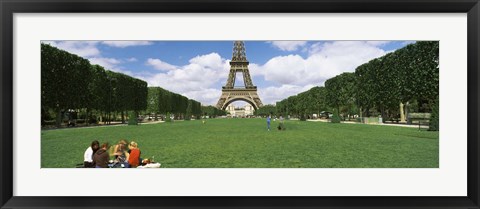 Framed Tourists sitting in a park with a tower in the background, Eiffel Tower, Paris, Ile-de-France, France Print