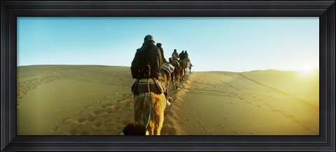Framed Row of people riding camels through the desert, Sahara Desert, Morocco Print