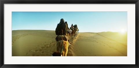 Framed Row of people riding camels through the desert, Sahara Desert, Morocco Print