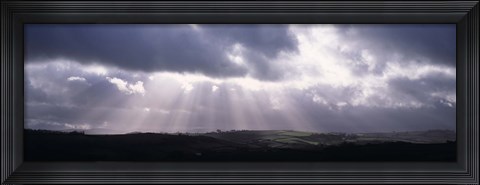 Framed Sunbeams radiating through dark clouds over rolling hills, Dartmoor, Devon, England Print
