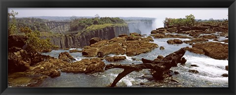 Framed Log on the rocks at the top of the Victoria Falls with Victoria Falls Bridge in the background, Zimbabwe Print