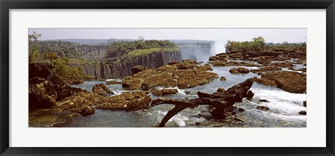 Framed Log on the rocks at the top of the Victoria Falls with Victoria Falls Bridge in the background, Zimbabwe Print