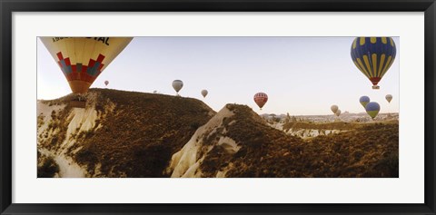 Framed Hot air balloons soaring over a mountain ridge, Cappadocia, Central Anatolia Region, Turkey Print