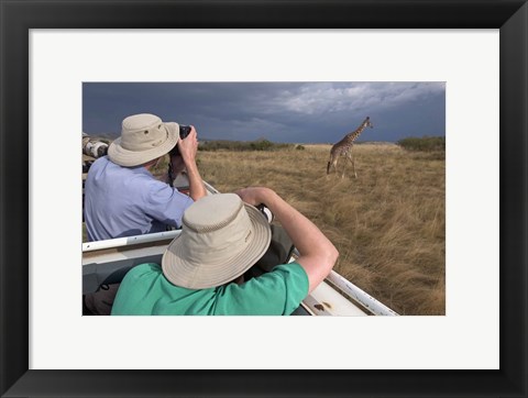 Framed Rear view of two safari photographers filming a giraffe Print