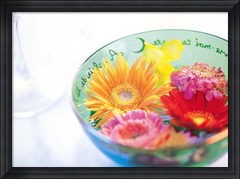 Framed Pink, orange and yellow flowers floating in a blue bowl Print