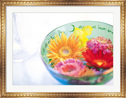 Framed Pink, orange and yellow flowers floating in a blue bowl Print