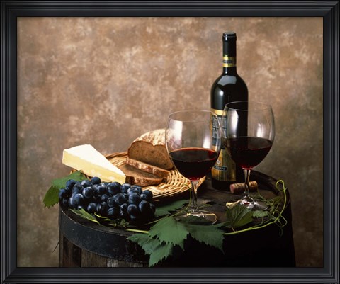 Framed Still life of wine bottle, wine glasses, cheese and purple grapes on top of barrel Print