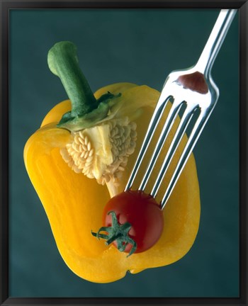 Framed Close up of half yellow pepper with cherry tomato in center on fork tines Print