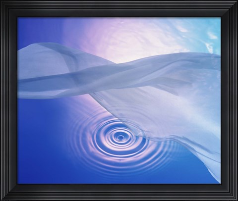 Framed Downward view of ring in lavender water with floating fabric in foreground and brightly lit background Print