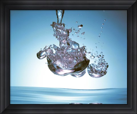 Framed Iridescent water bubble formation floating above the surface of deep blue water Print