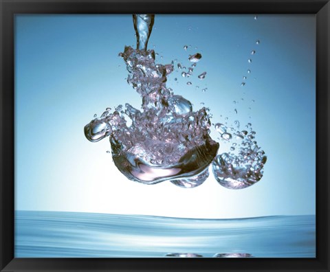 Framed Iridescent water bubble formation floating above the surface of deep blue water Print