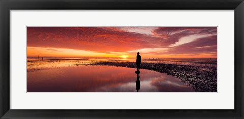 Framed Silhouette of human sculpture on the beach at sunset, Another Place, Crosby Beach, Merseyside, England Print