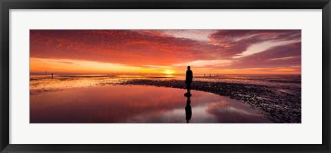 Framed Silhouette of human sculpture on the beach at sunset, Another Place, Crosby Beach, Merseyside, England Print