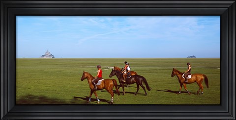 Framed Horseback riders in a field with Mont Saint-Michel island in background, Manche, Basse-Normandy, France Print