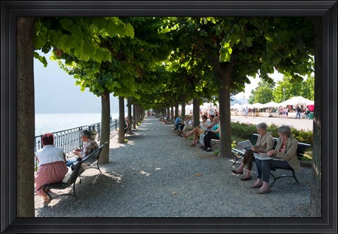 Framed People sitting on benches among trees at lakeshore, Lake Como, Cernobbio, Lombardy, Italy Print