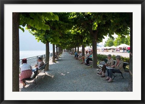 Framed People sitting on benches among trees at lakeshore, Lake Como, Cernobbio, Lombardy, Italy Print