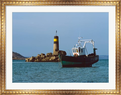 Framed Fishing trawler in front of a lighthouse at Port Saint-Sauveur, Ile Grande, Cotes-d&#39;Armor, Brittany, France Print