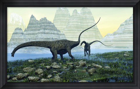Framed Diplodocus dinosaurs munch on vegetation near a mountain lake Print
