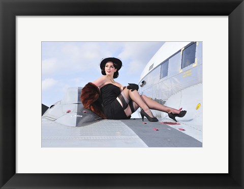 Framed Glamorous woman in 1940&#39;s style attire sitting on a vintage aircraft Print