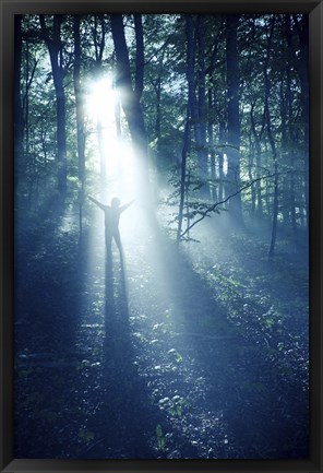 Framed Silhouette of a man standing in the misty rays of a dark forest, Denmark Print