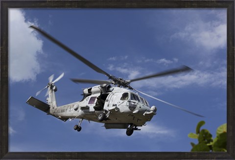 Framed Crew Chief looks out the side door of a helicopter in flight Print