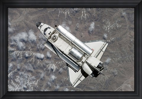 Framed Aerial view of Space Shuttle Discovery over Earth as it approaches the International Space Station Print