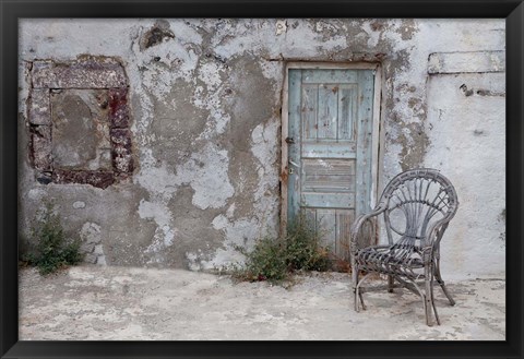 Framed Old Building chair and doorway in town of Oia, Santorini, Greece Print