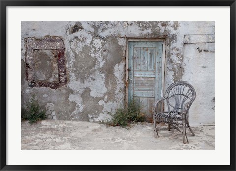 Framed Old Building chair and doorway in town of Oia, Santorini, Greece Print