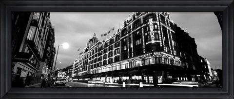 Framed Low angle view of buildings lit up at night, Harrods, London, England BW Print