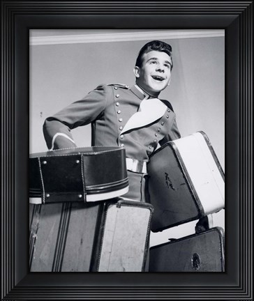 Framed 1950s Smiling Bellboy Carrying Four Bags Of Luggage Print