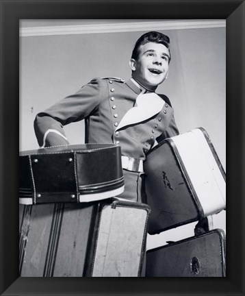 Framed 1950s Smiling Bellboy Carrying Four Bags Of Luggage Print