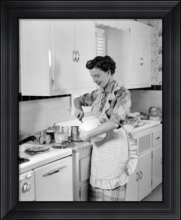 Framed 1950s Housewife In Kitchen Mixing Ingredients Print