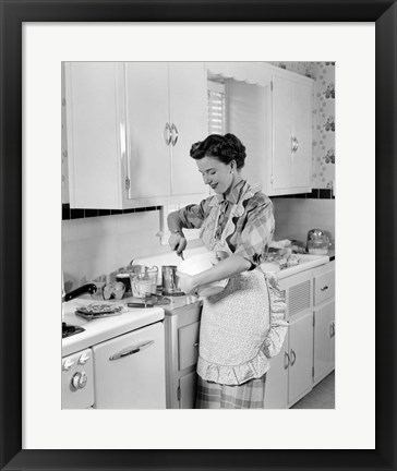 Framed 1950s Housewife In Kitchen Mixing Ingredients Print